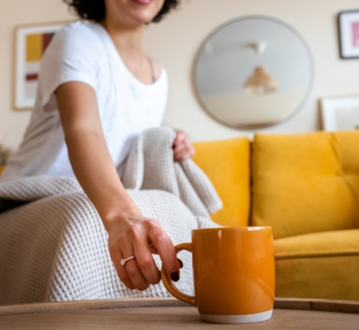 Woman setting down cup of coffee.