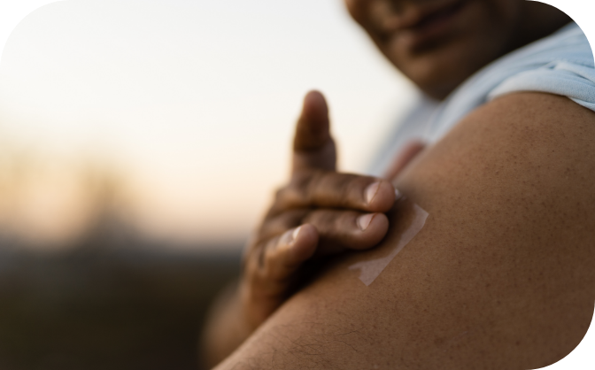 Person applying nicotine patch to their shoulder